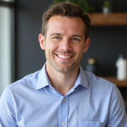 Professional headshot of a male nutritionist with a friendly, confident expression, wearing a smart casual outfit, against a modern, clean background.